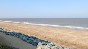 A beach with a rocky shoreline and a clear sky. - Kingfisher Lodge (Great Yarmouth)