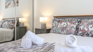 A hotel room with a bed, two nightstands, a mirror, and artwork on the walls. - Tan Llech (Harlech)