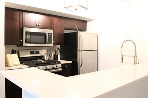 Enjoy cooking in this fully equipped kitchen with a sink, microwave, oven, and refrigerator.
