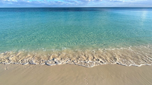 A beach with clear turquoise water and a sandy shore. - Beach Front Condo with Ocean View (Freeport)