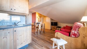 A compact living space with a kitchen, dining area, and seating area. - Les Alpages du Corbier C301 - Piscine partagée (Villarembert)