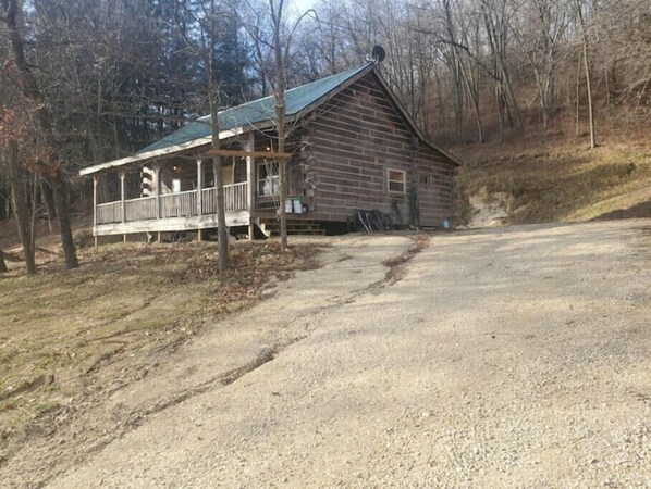 A rustic cabin with a porch and a dirt driveway. - Larsen Hunters Rustic Cabin
(Wauzeka)