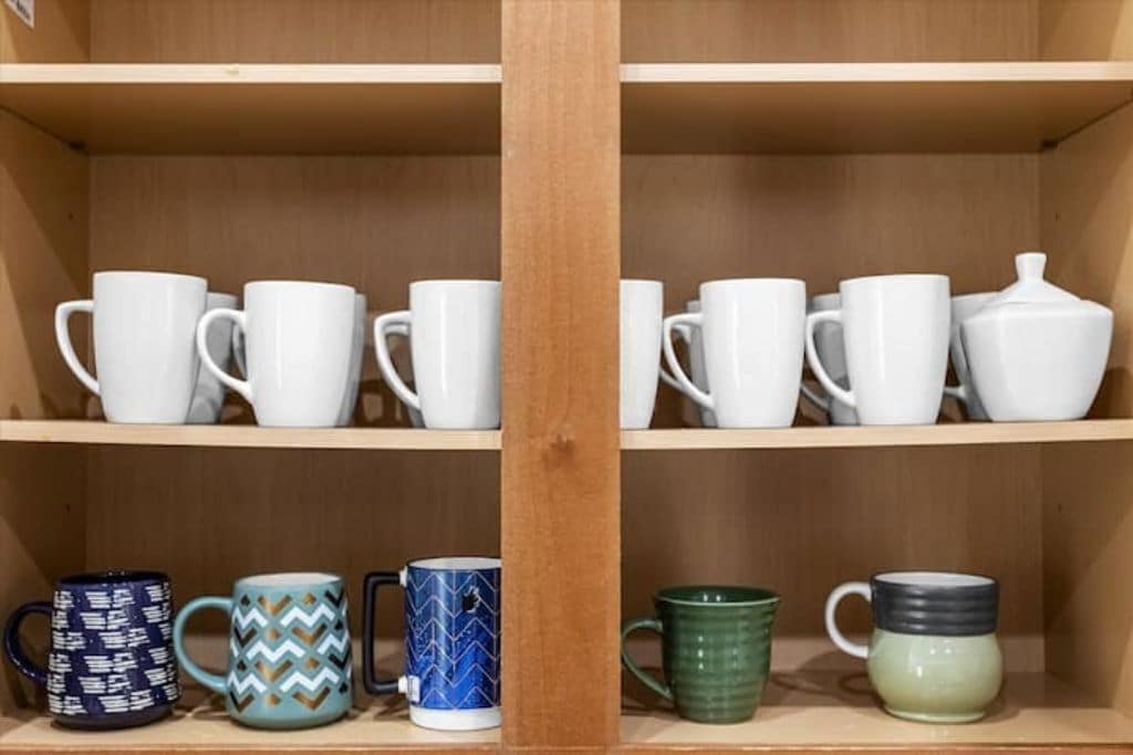 Una repisa con tazas blancas y de diseño.