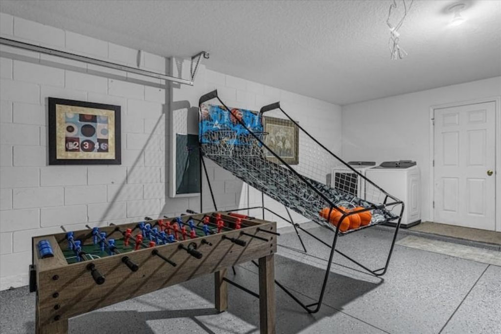 Une pièce avec une table de baby-foot, une échelle en métal et une porte.