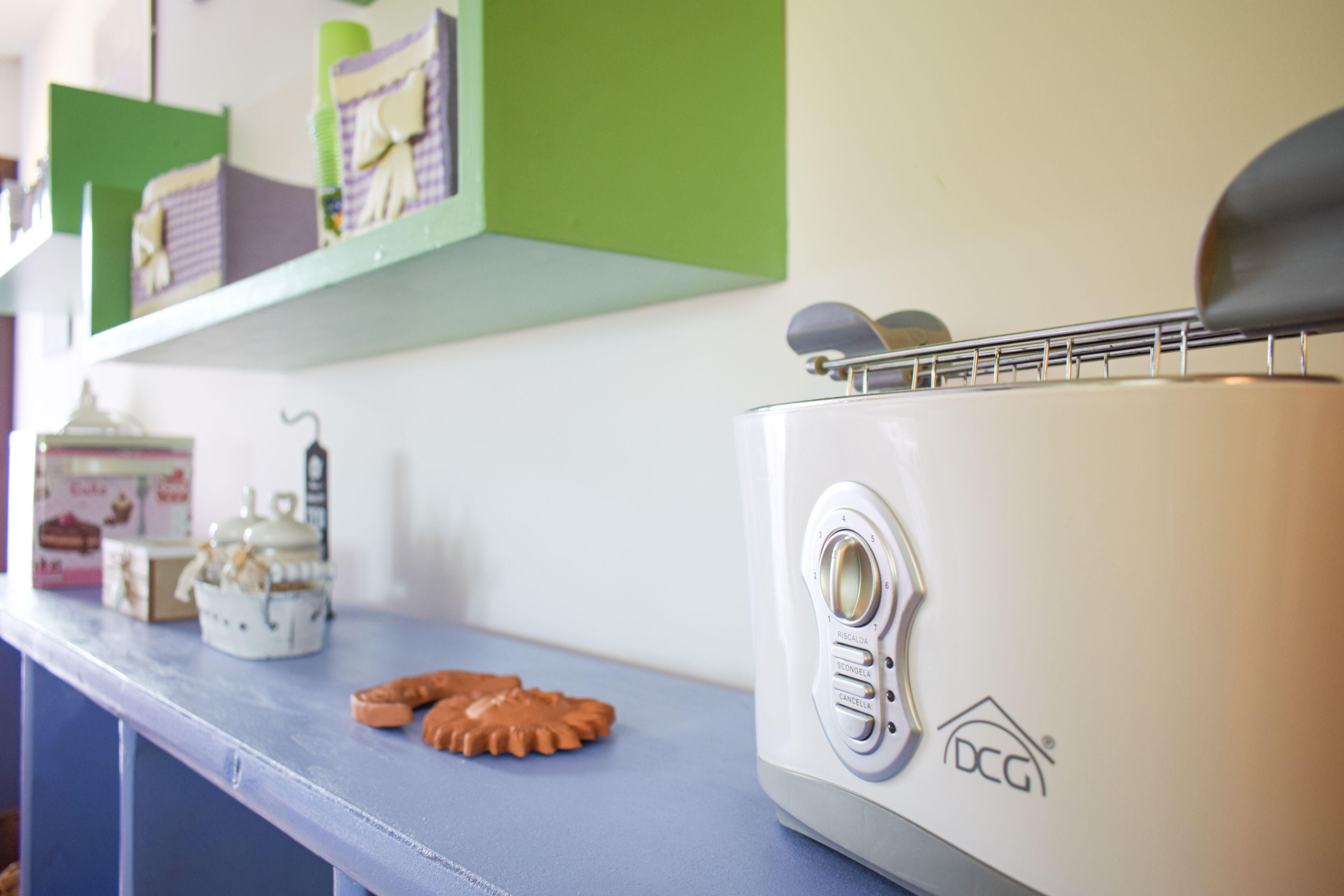A kitchen counter with a toaster, a cookie cutter, and a box of tea.