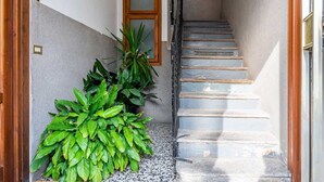 Ein schmaler Gang mit einer Treppe, die zu einer Holztür führt.