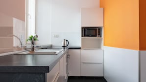 A modern kitchen with a sink, kettle, and microwave. - ESPERANTO HOME (Katowice)