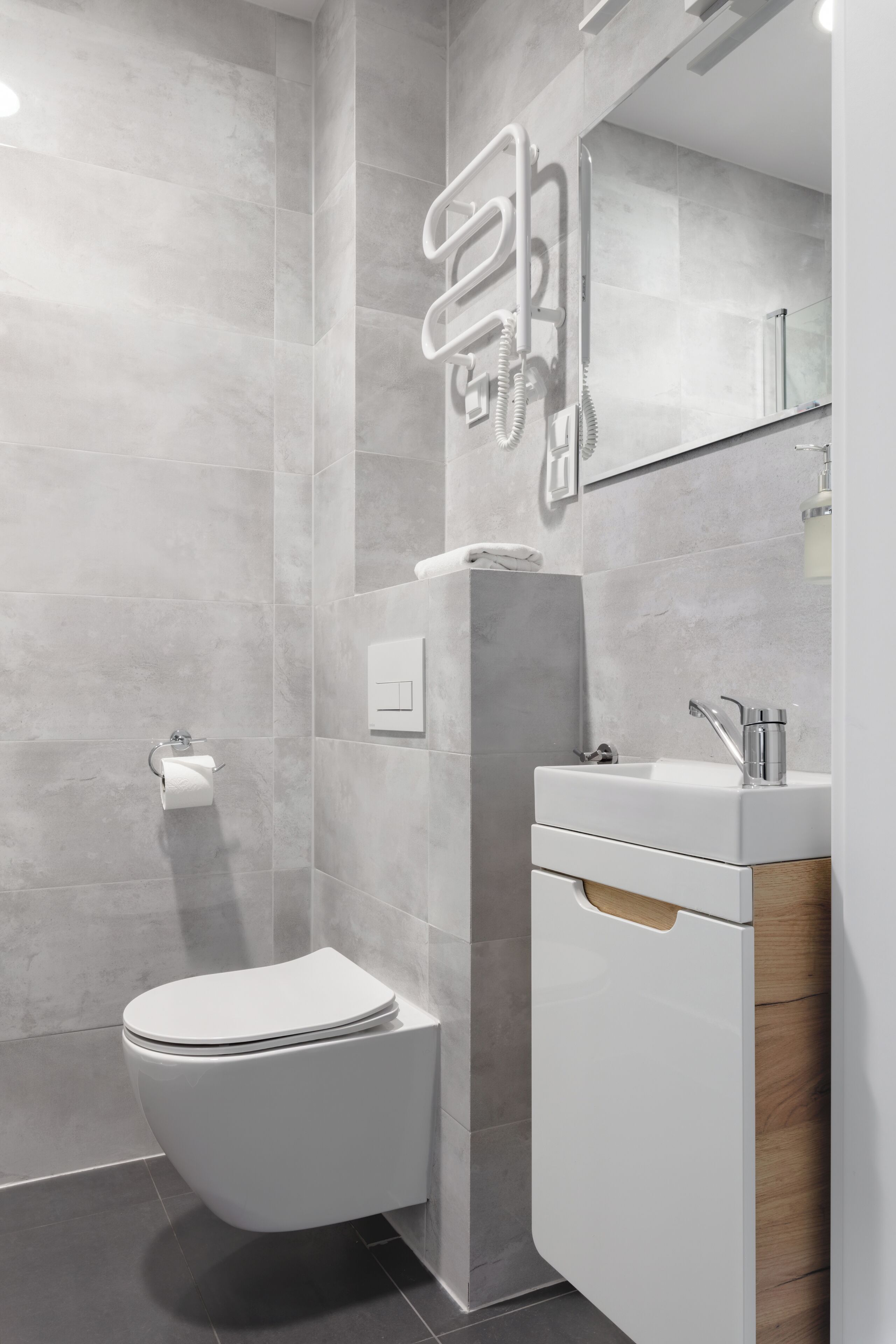 A modern bathroom with a toilet, sink, and shower area.