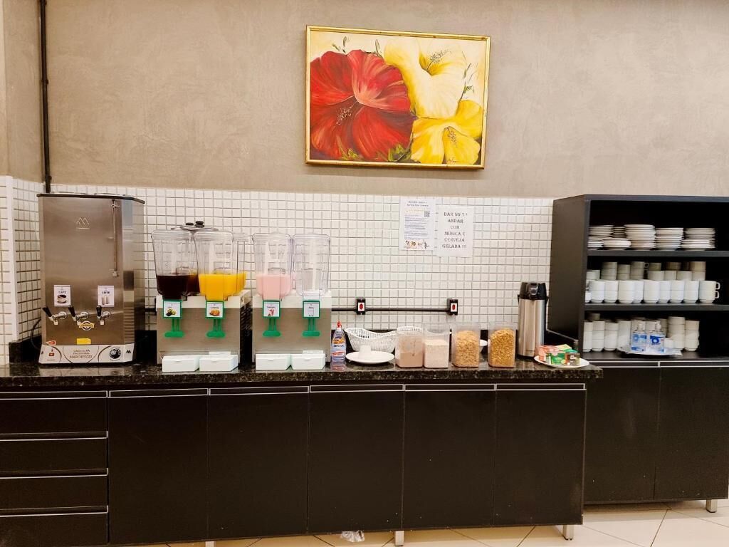 Una estación de café con varios dispensadores de bebidas, una máquina de café y una variedad de alimentos en una encimera.