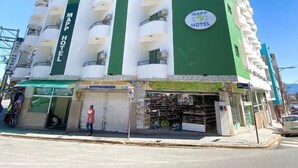 A multi-story hotel with a green and white facade, multiple balconies, and a sign indicating it is a hotel. - MAPP HOTEL (Aparecida)