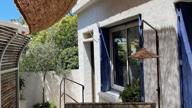 A patio with a wooden table, a hanging shade, and a potted plant. - Maison DE Ville Vallon DES Auffes (Marseille)