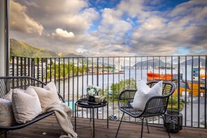 A balcony with a view of a body of water, mountains, and a cityscape. - New! Luxurious Seafront Apt! Free Parking (Vestland)
