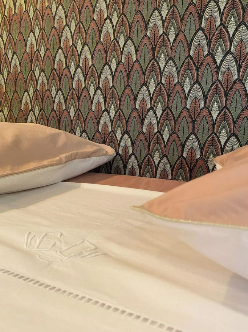 Un lit avec une tête de lit à motifs et des oreillers.