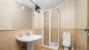 Ein Badezimmer mit einem Standwaschbecken, Toilette und einer Duschkabine.
