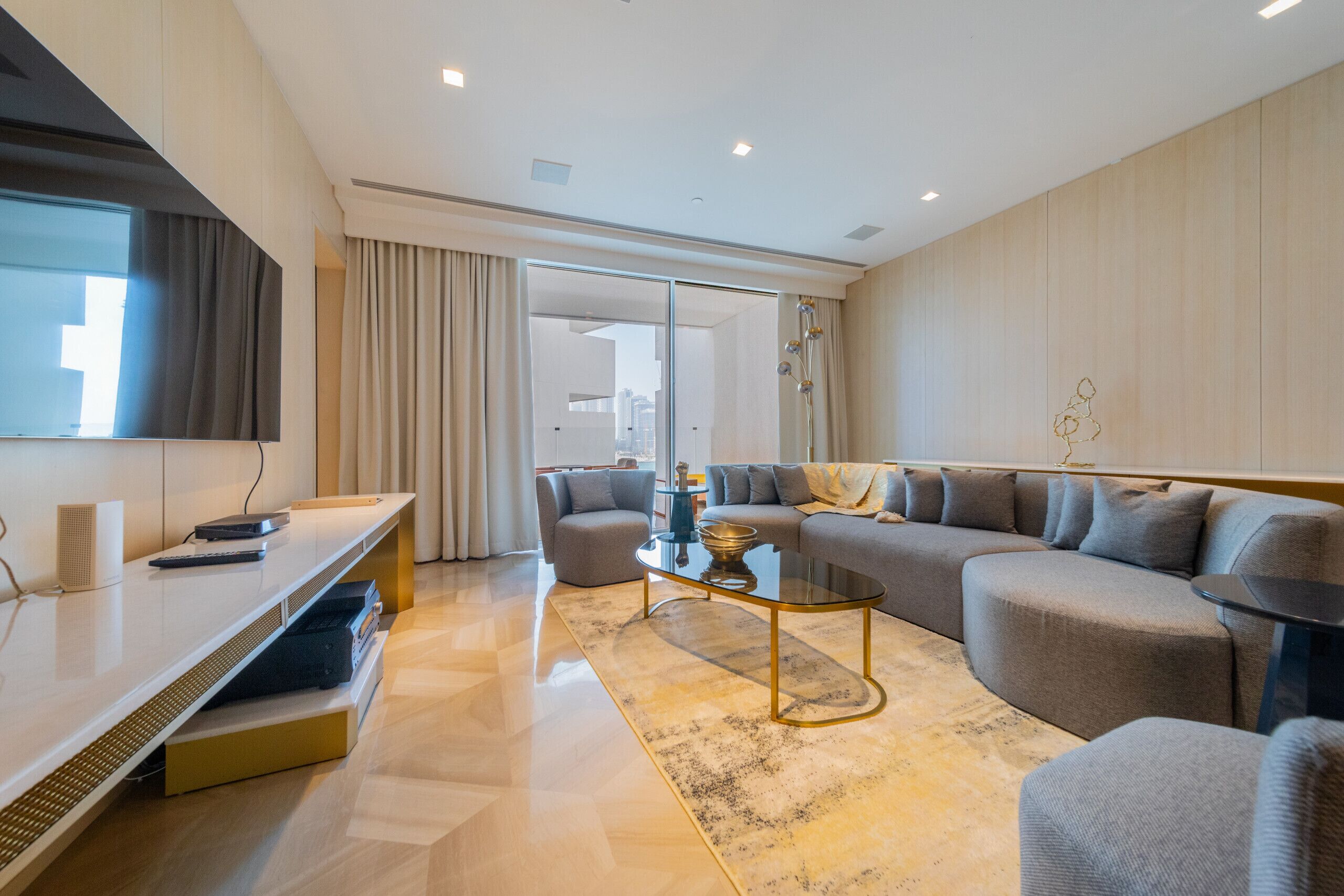 A modern living room with a sofa, a coffee table, and a TV.