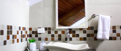 A bathroom with a white sink, a mirror, and a towel rack.