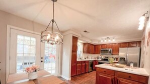 Una cocina moderna con armarios de madera, una isla central y electrodomésticos de acero inoxidable.