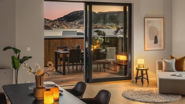 Ein modernes Wohnzimmer mit einer Schiebetür zu einer Außen-Terrasse.