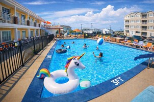 Una piscina al aire libre de temporada, sillones reclinables de piscina