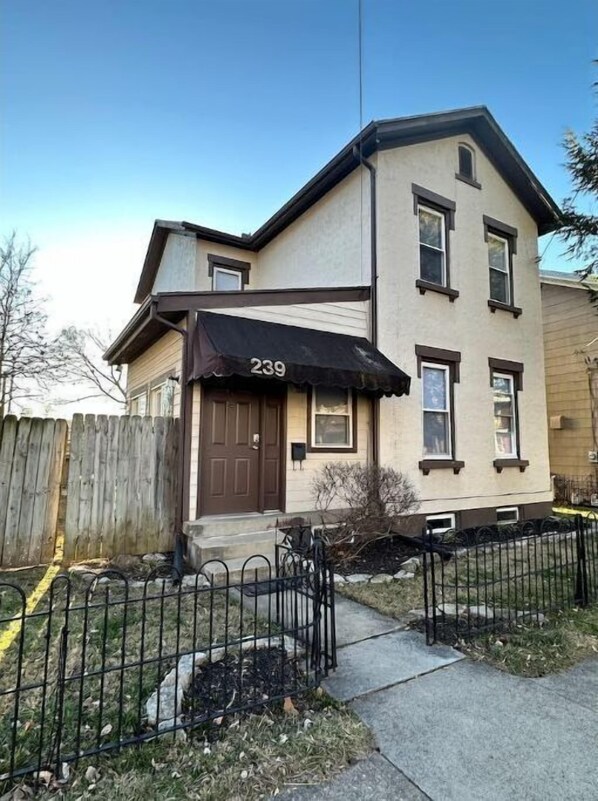 A two-story building with a brown door and a black awning displaying the number 239. - Farmhouse in the City (Dayton)