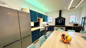 Una cocina moderna con una isla central, electrodomésticos integrados y un área de comedor con un frutero.