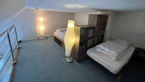 A small, compact room with a bunk bed, a bedside table, and two floor lamps. - Charming cocoon (Cabourg)