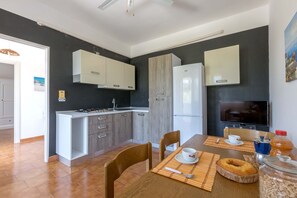 Enjoy meals in this kitchen with stove, refrigerator, and dining area for two.