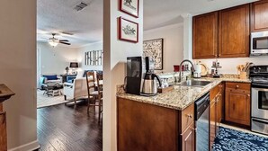 A kitchen with wooden cabinets, a granite countertop, a coffee maker, and a microwave.