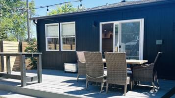 An outdoor deck with wicker furniture, a table, and a bench.