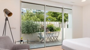 A modern bedroom with a large sliding glass door leading to an outdoor patio.