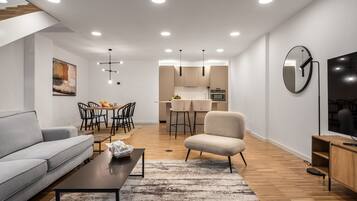 Una sala de estar moderna con un sofá, una mesa de centro y un comedor con sillas y una mesa.