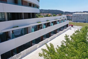 A modern building with multiple balconies, large windows, and a flat roof.