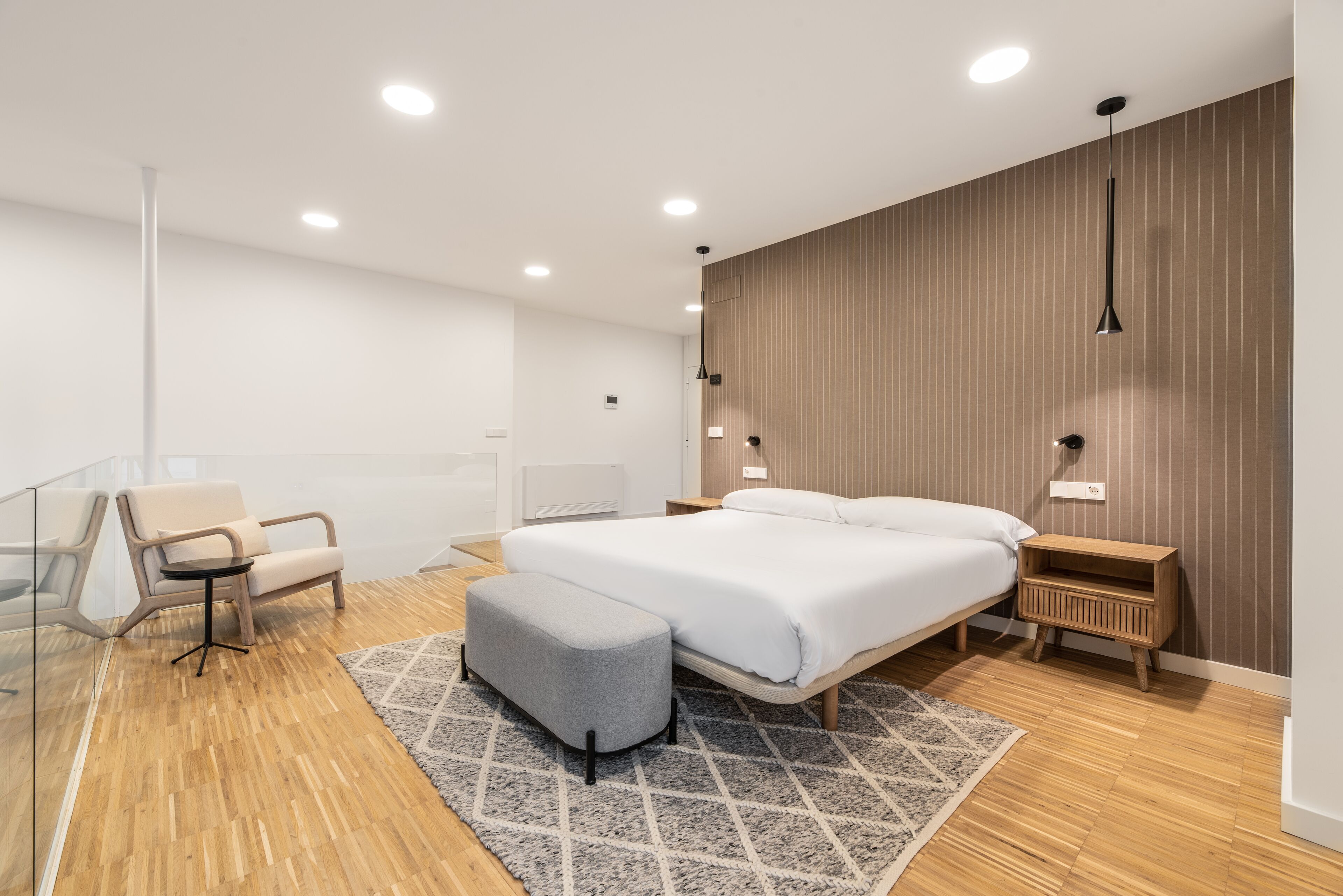 A modern bedroom with a bed, a desk, and a chair.