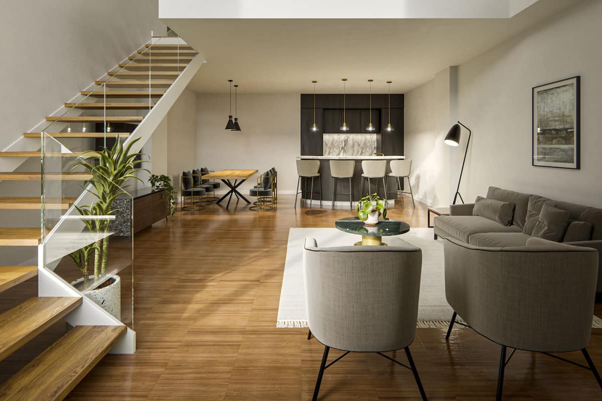 A spacious living area with a high ceiling, a staircase leading to an upper level, and a kitchen area in the background.