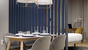 Un espace repas moderne avec une table en bois, des chaises à revêtement gris et un séparateur bleu composé de lattes verticales.