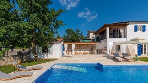 A swimming pool with lounge chairs and a stone wall. - Lavova in Brtonigla With 3 Bedrooms and 2 Bathrooms (Brtonigla)