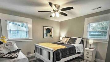 2 habitaciones, escritorio y tabla de planchar con plancha