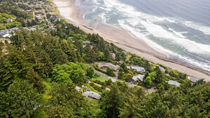 Vue aérienne d’une zone résidentielle côtière, avec des maisons, des routes et une plage.