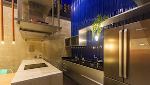 Una cocina moderna con electrodomésticos de acero inoxidable, horno empotrado y encimera negra.