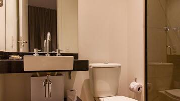 A modern bathroom with a white sink, toilet, and shower.