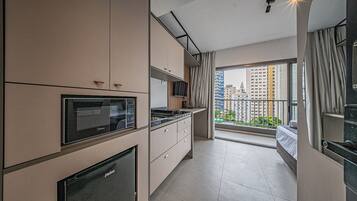 A modern kitchen with a built-in oven, microwave, and a large window offering a city view.