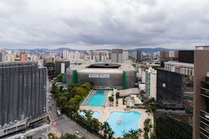 Un edificio grande con piscina y cancha de tenis, rodeado de otros edificios.