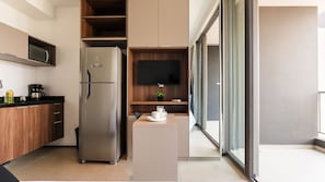 Una cocina moderna con refrigerador integrado, microondas y cafetera.