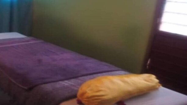 Uma cama com um cobertor roxo e um travesseiro.