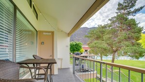 A balcony with wicker furniture, a view of a mountain, and a grassy area with a tree. - Lovely Crescent Bar Condo w/ Community Amenities! (Quincy)