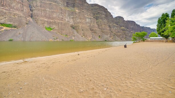 A sandy beach with a rocky cliff in the background. - Lovely Crescent Bar Condo w/ Community Amenities! (Quincy)