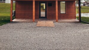 A small, single-story wooden building with a metal roof, a front door, and a small window. - The Elk Cabin - Hidden Acres Cabins (Bethany)