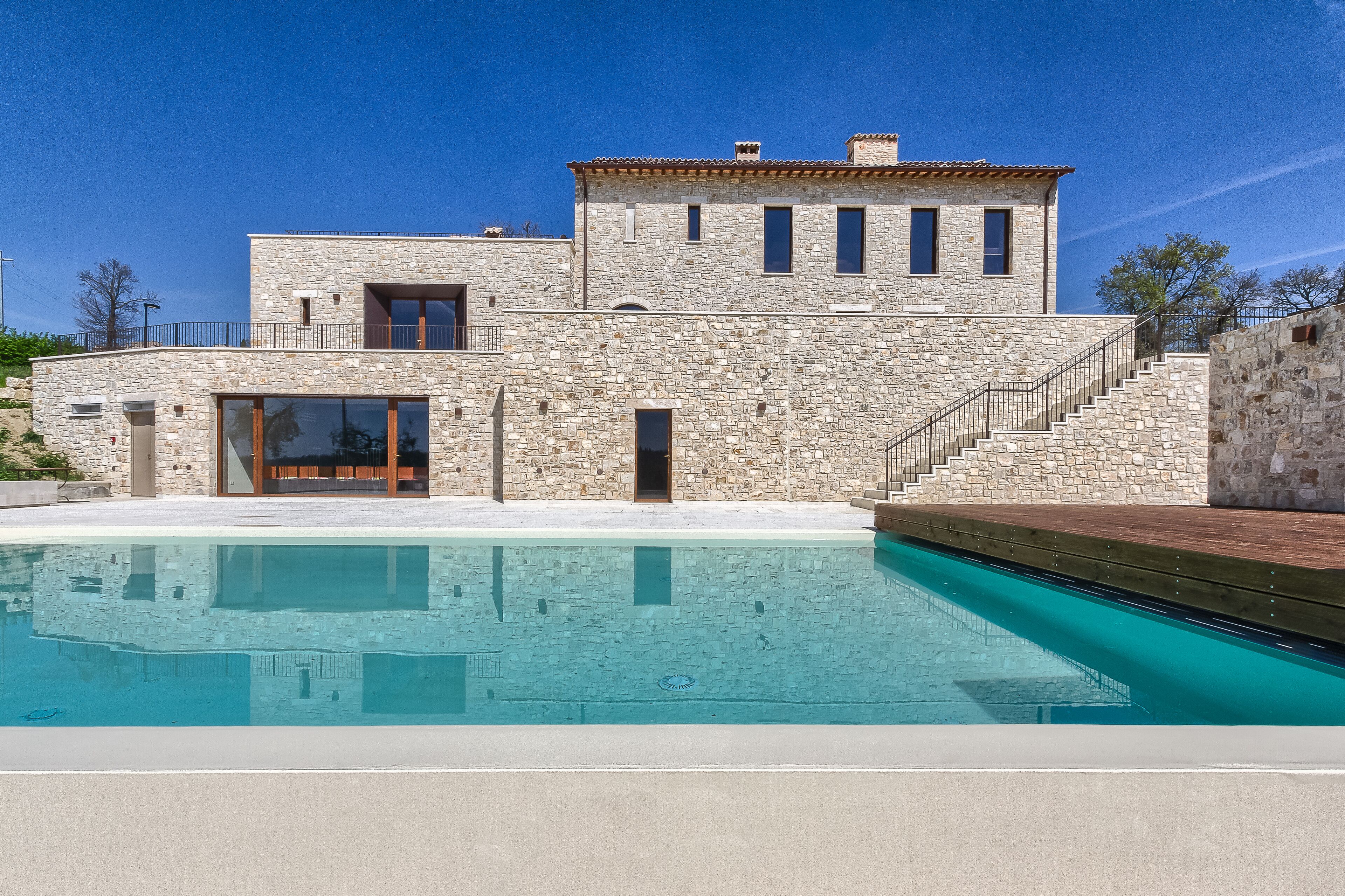 Un edificio de piedra con una piscina delantera.