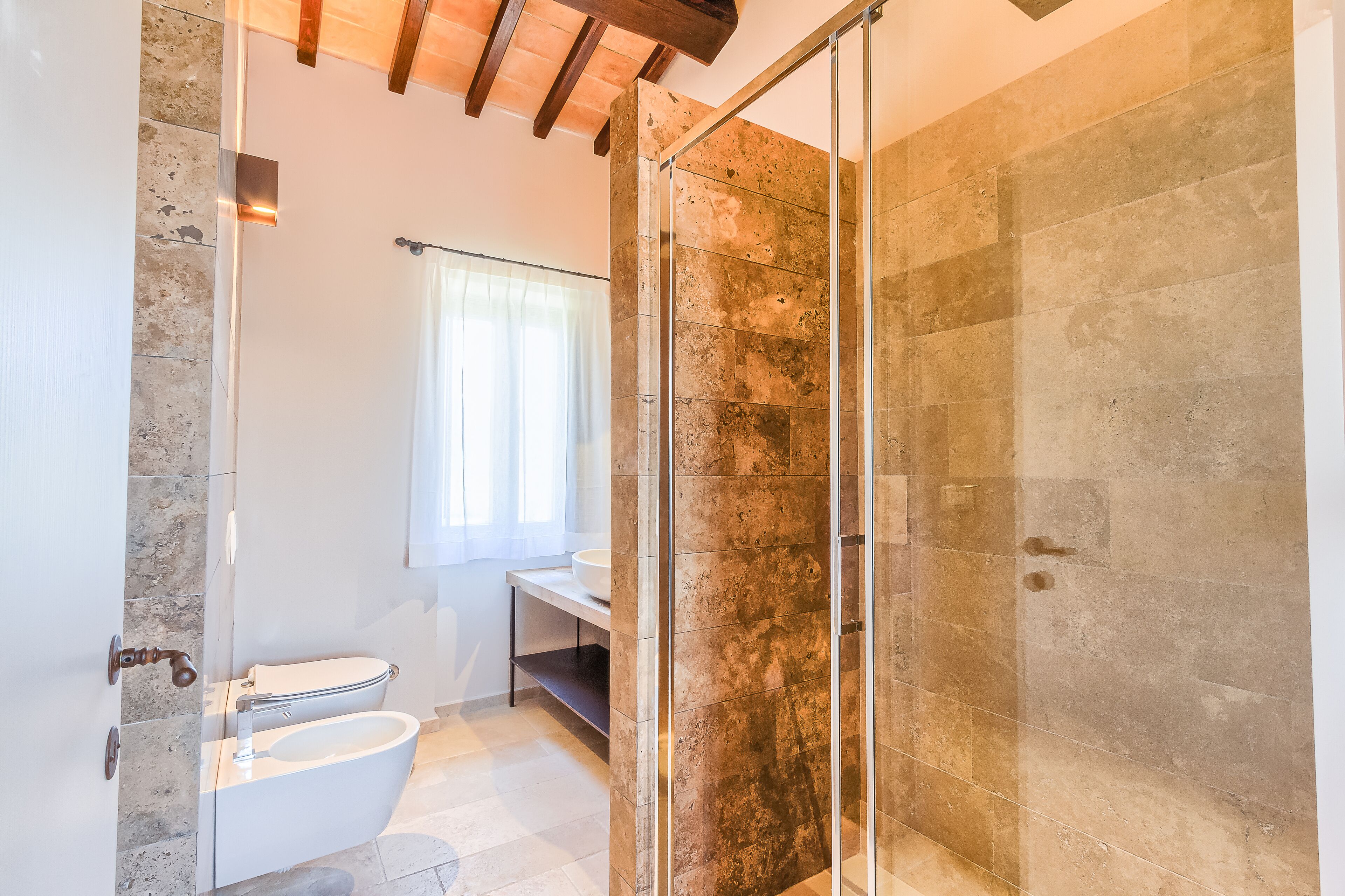 Une salle de bain moderne avec une douche à parois de verre, des toilettes blanches et un lavabo.