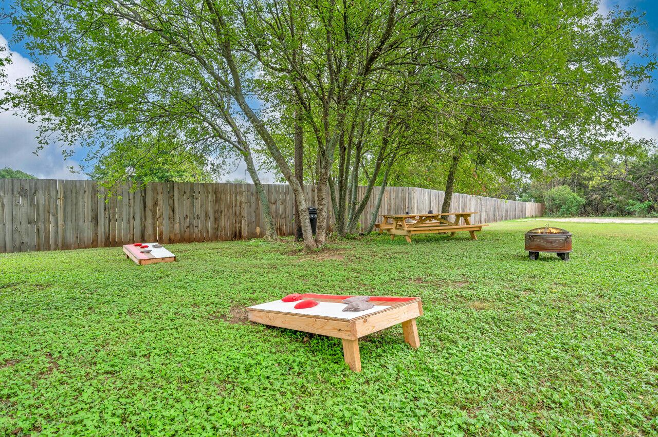 Un cortile con un tavolo di legno, un tavolo da picnic e un baule di legno.